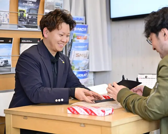 テーブルを挟んで商談をしている二人。