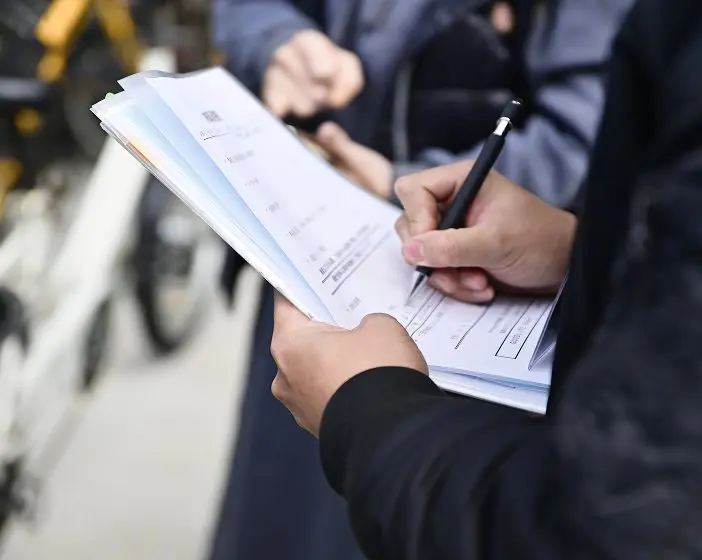 書類に記入している人の手元。